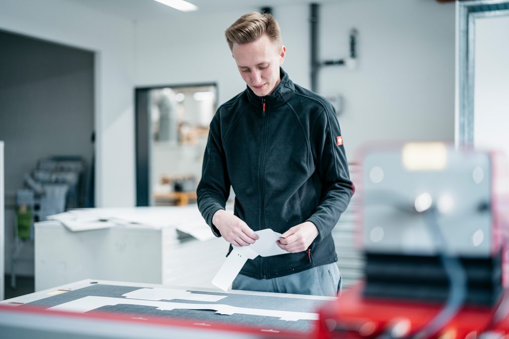 Ein MEDIAHAUS-Mitarbeiter steht an einer Maschine.